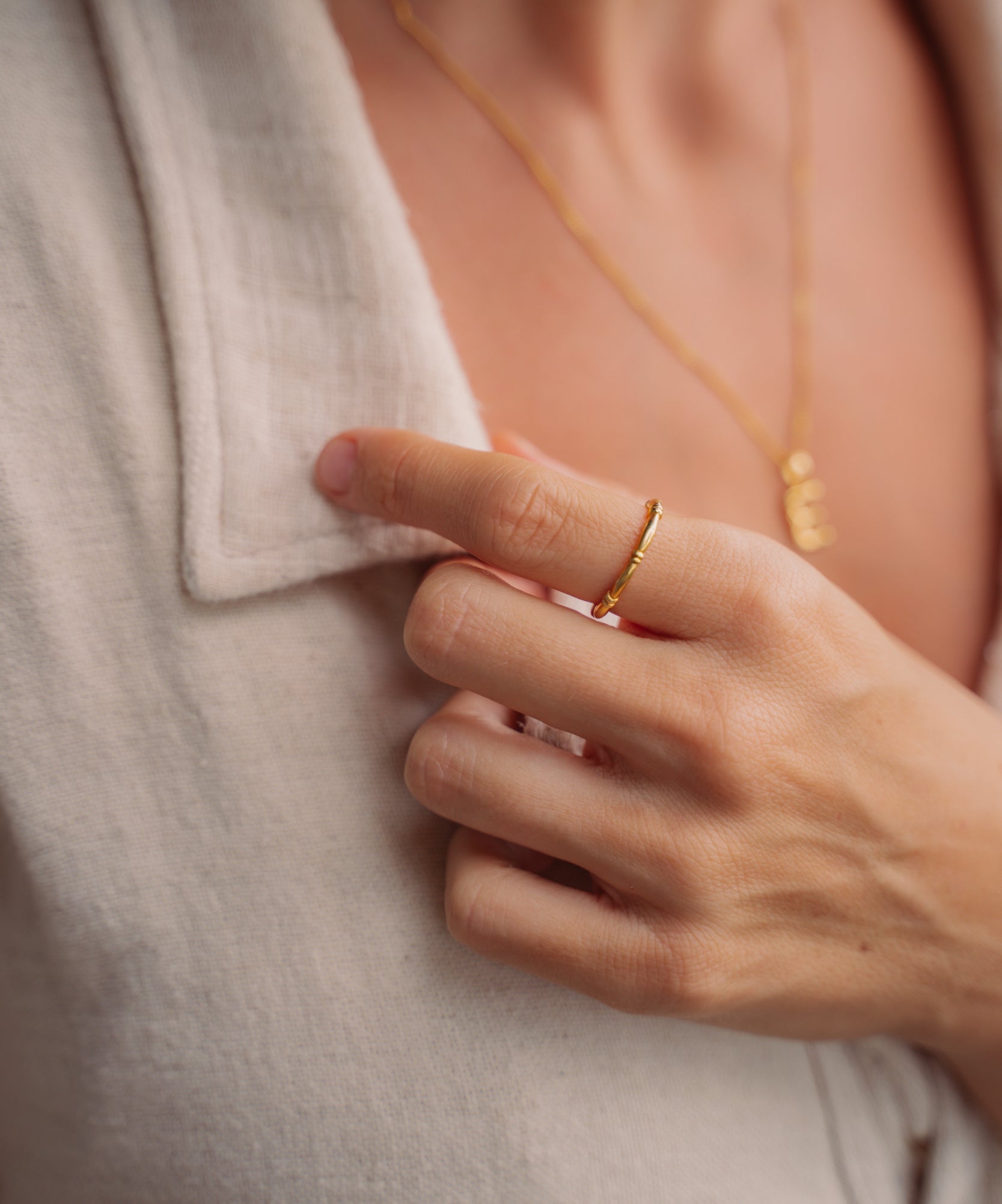 model trägt goldenen Ring kombiniert mit beigem Hemd. Hati Ring von VERLAN