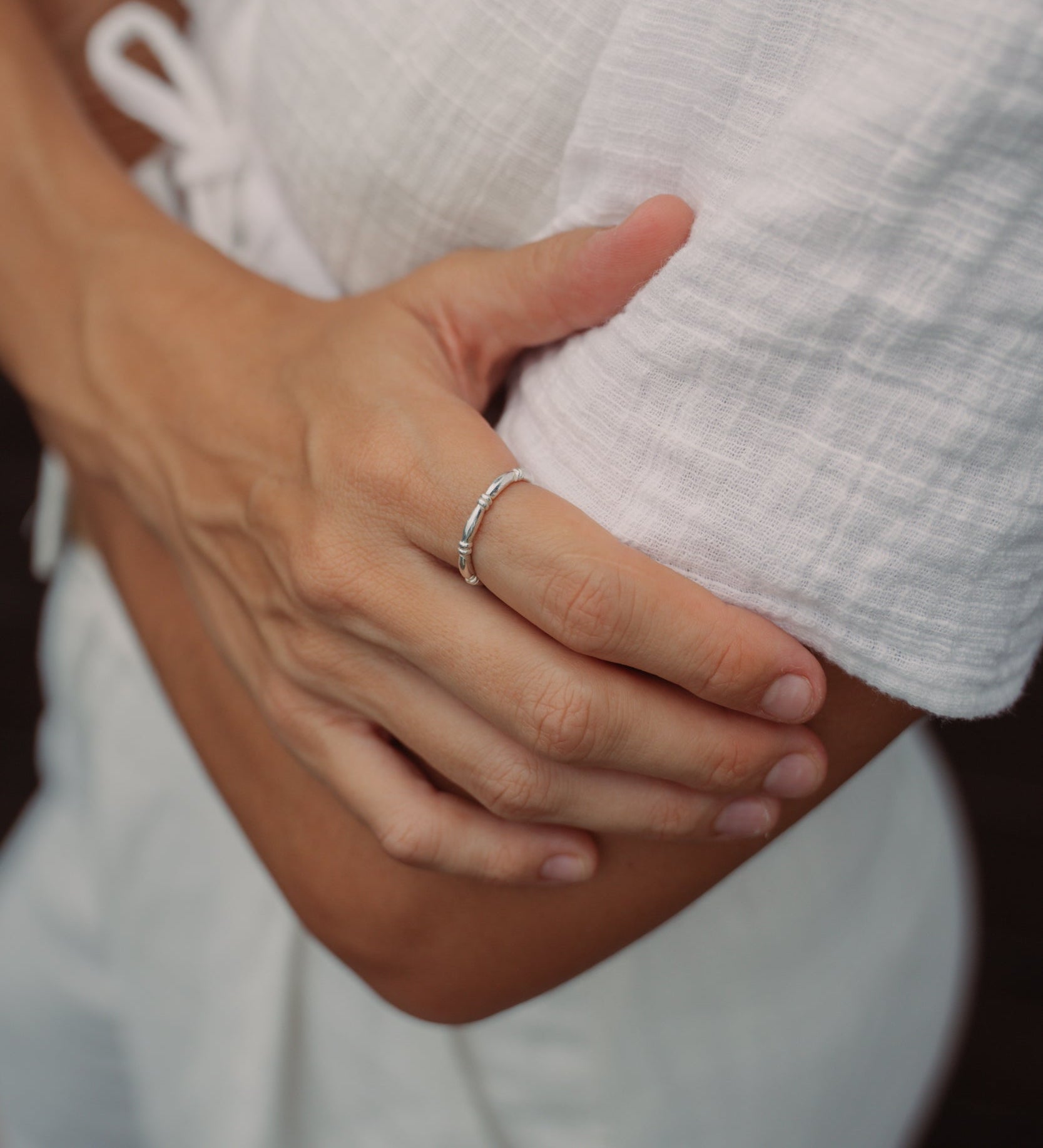 Model mit silbernem HATI Ring am Zeigefinger von VERLAN Jewellery. Wasserfester Schmuck aus Bali. Echt Silber Ring mit kleinen Perlen