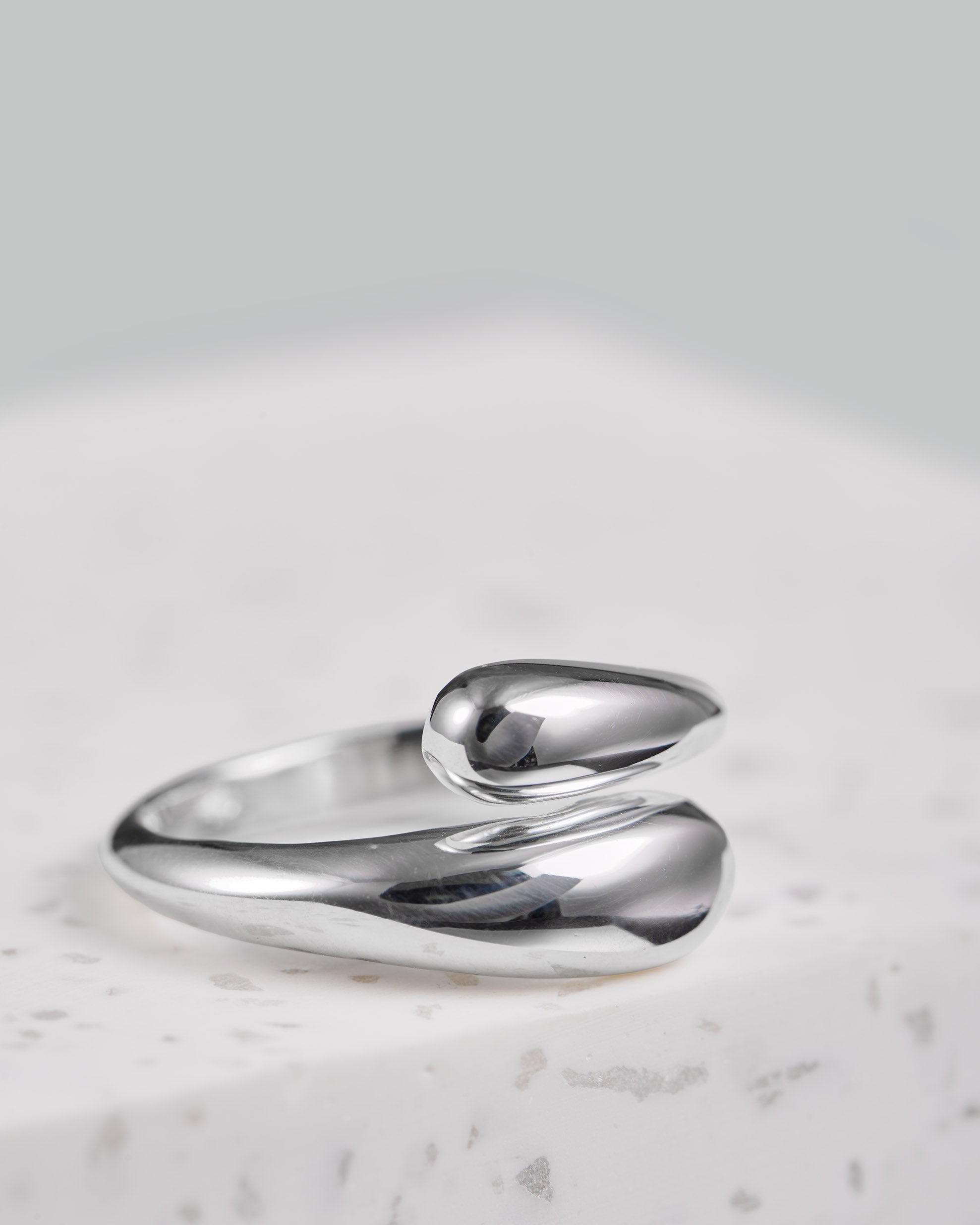 Silber Ring in Tropfen Form, der sich verstellen lässt. Das Model trägt den Ring am Zeigefinger und trägt ihn als Statement Ring.