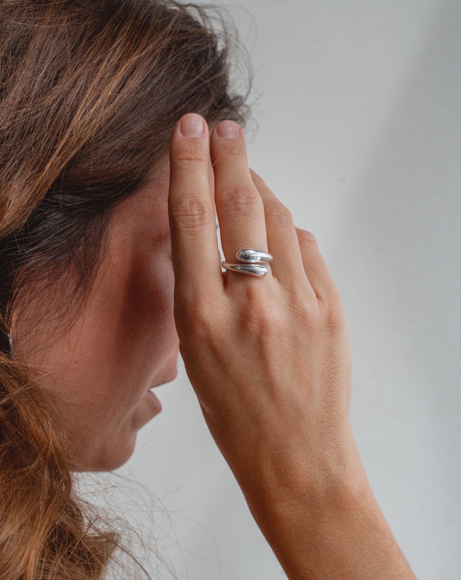 Silber Ring in Tropfen Form, der sich verstellen lässt. Das Model trägt den Ring am Zeigefinger und trägt ihn als Statement Ring.